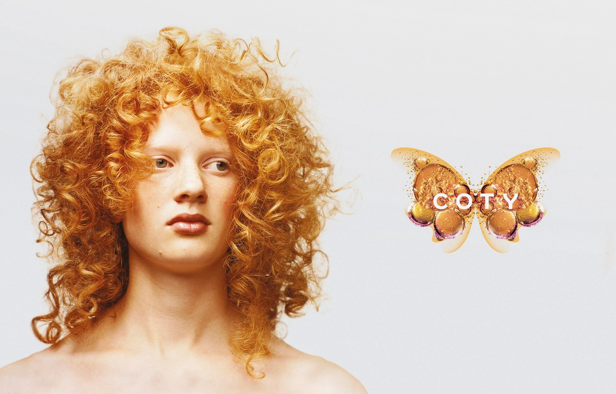 Coty's butterfly identity, formed from golden liquid and bubble textures with the Coty wordmark at its centre